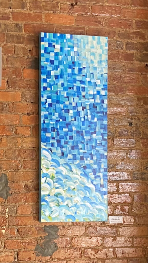 A painting of blue water on the side of a brick wall.
