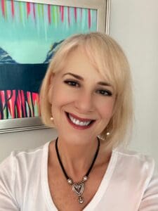 Smiling woman wearing a heart necklace.